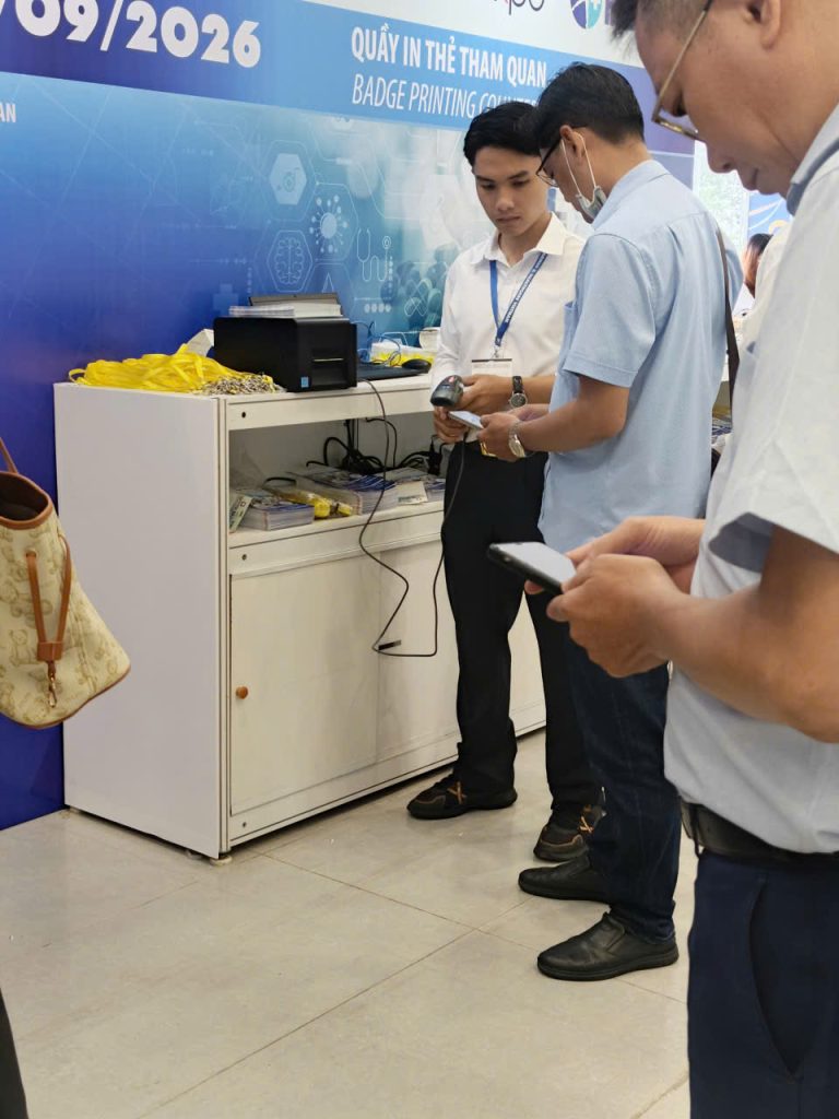 Nhân viên hỗ trợ khách in thẻ vào sự kiện